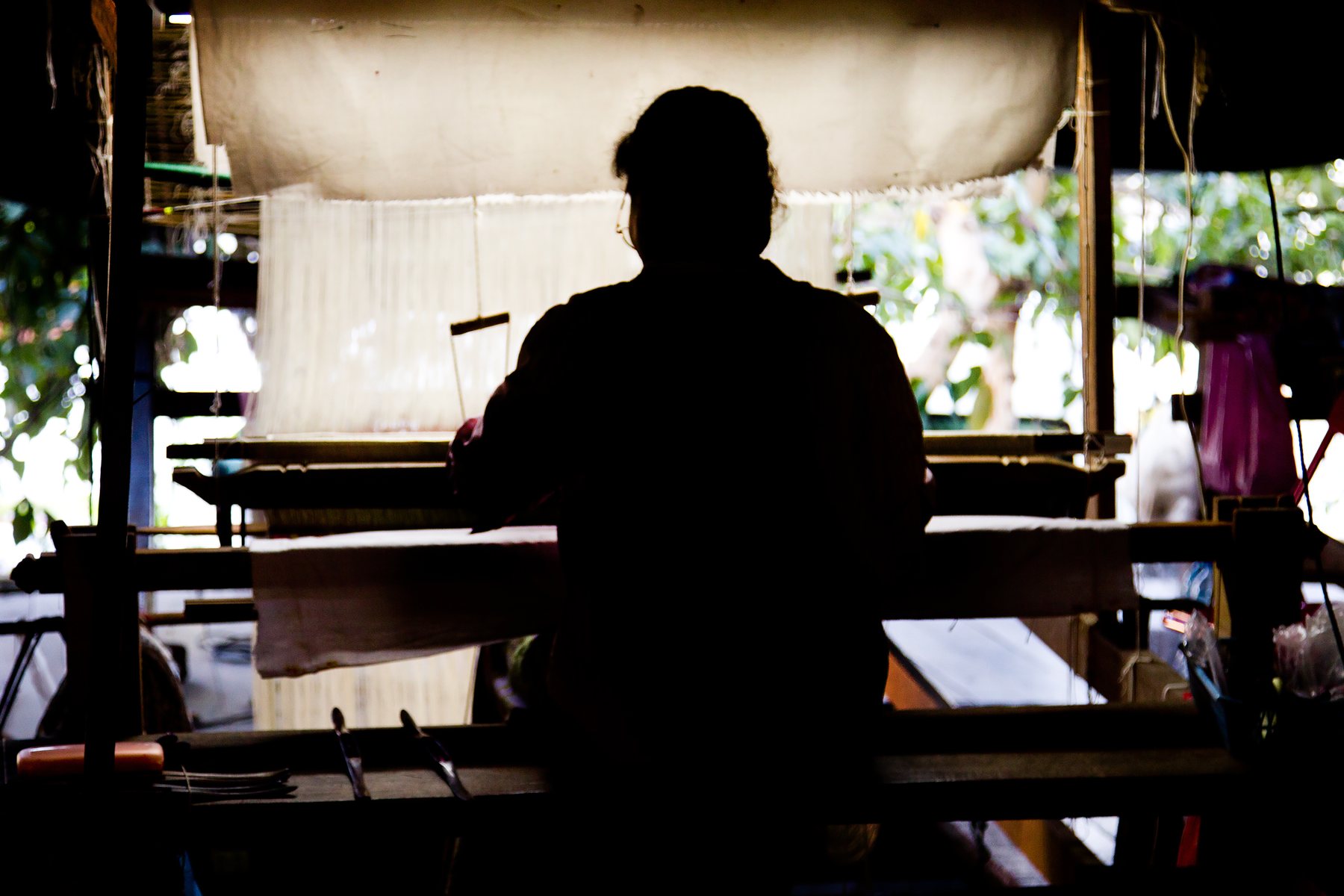 Thai silk artisan weaving at a loom