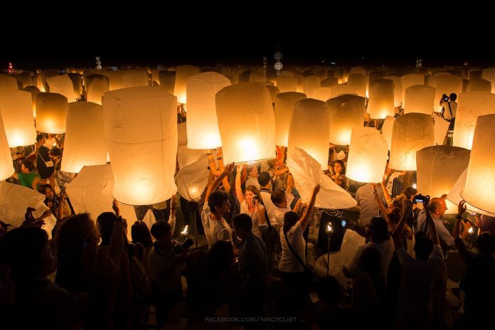People launching sky lanterns during Yi Peng in Chiang Mai People launching sky lanterns during Yi Peng in Chiang Mai