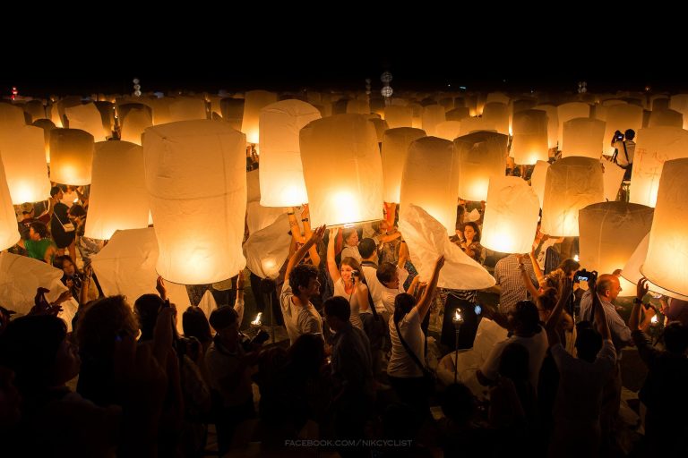 People launching sky lanterns during Yi Peng in Chiang Mai