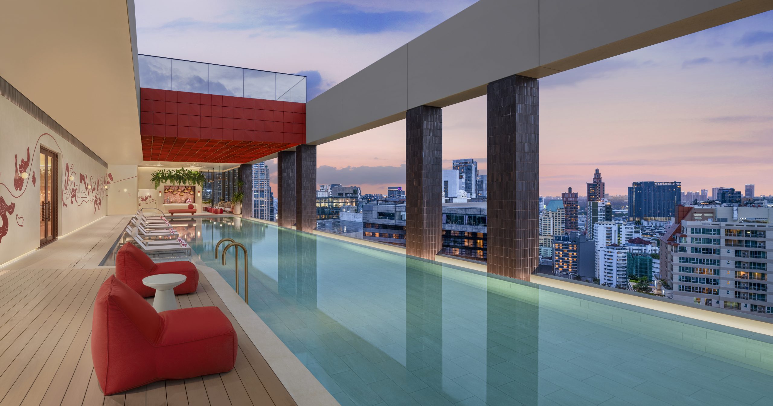 Outdoor swimming pool at KROMO Bangkok at twilight