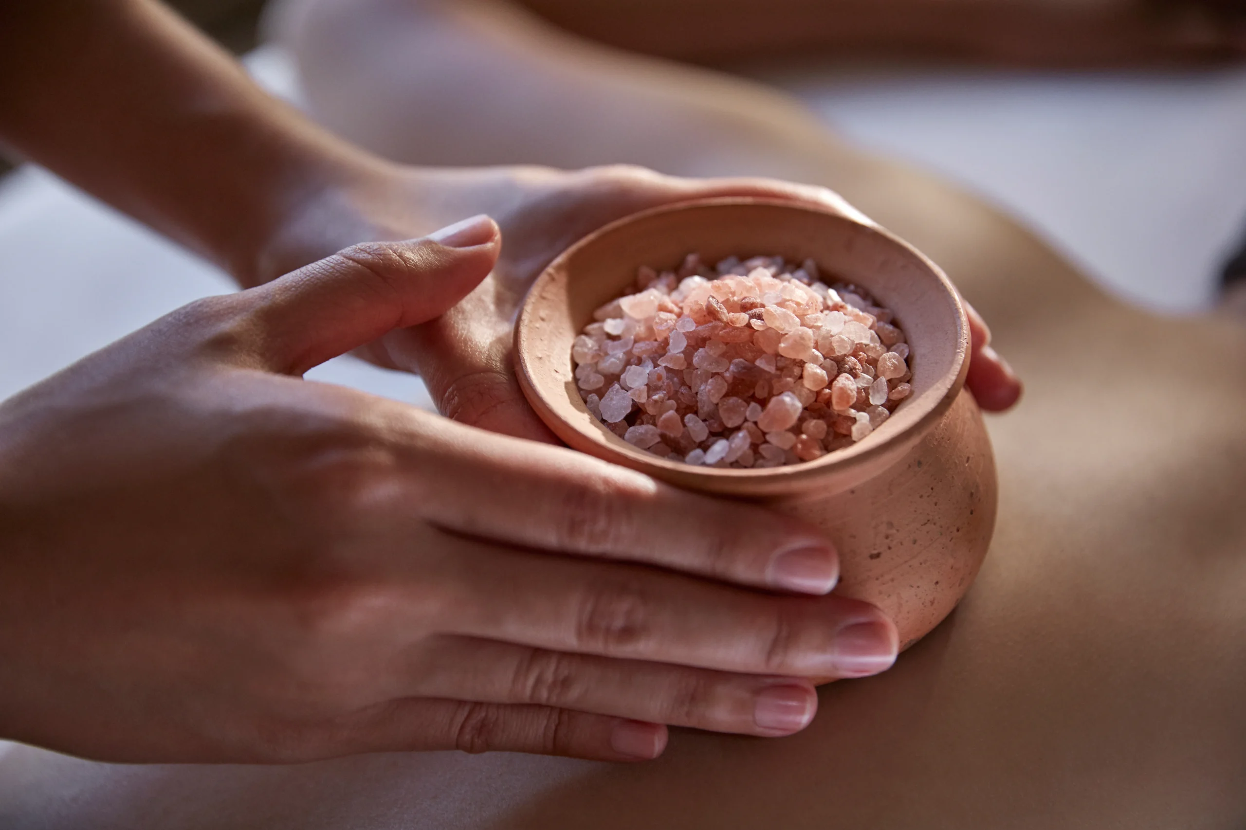 Therapist preparing a thermal salt treatment at The Oriental Spa Bangkok