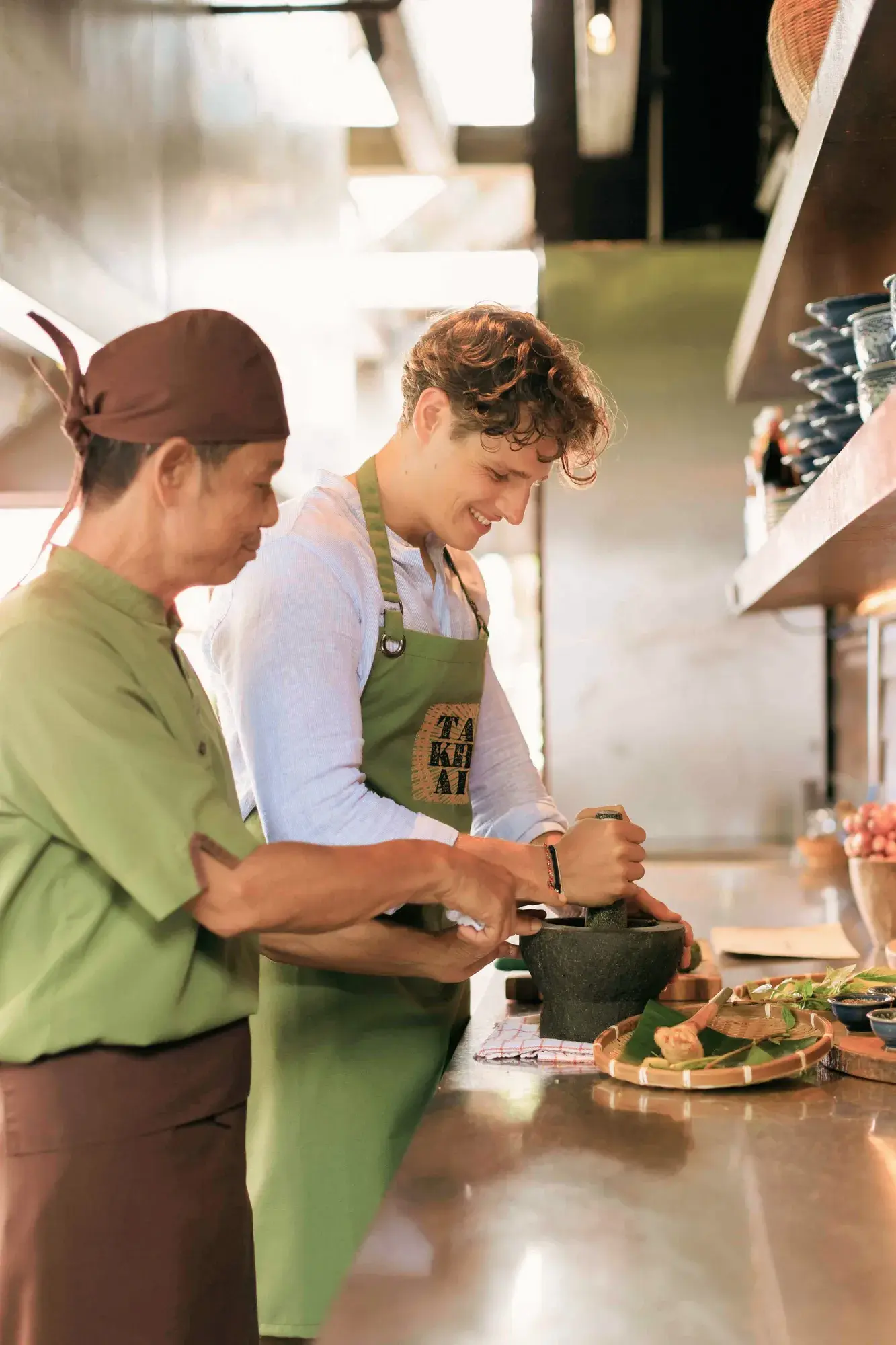 Thai chef demonstrating traditional preparation at Ta Khai