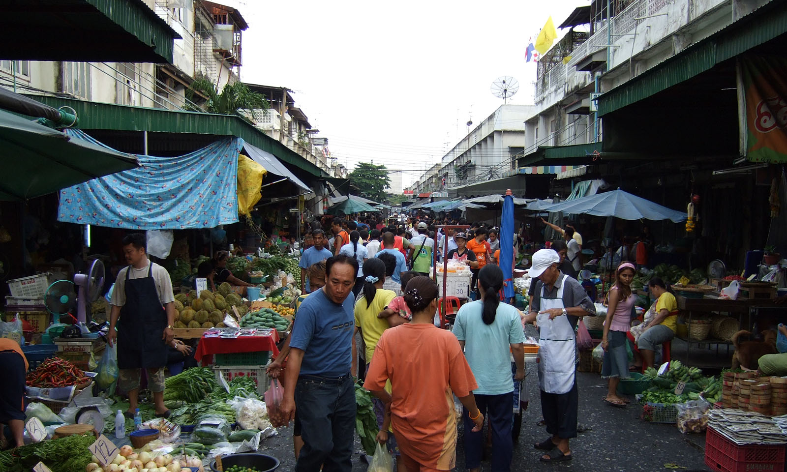 Fresh produce and shoppers inside Khlong Toei Market Bangkok