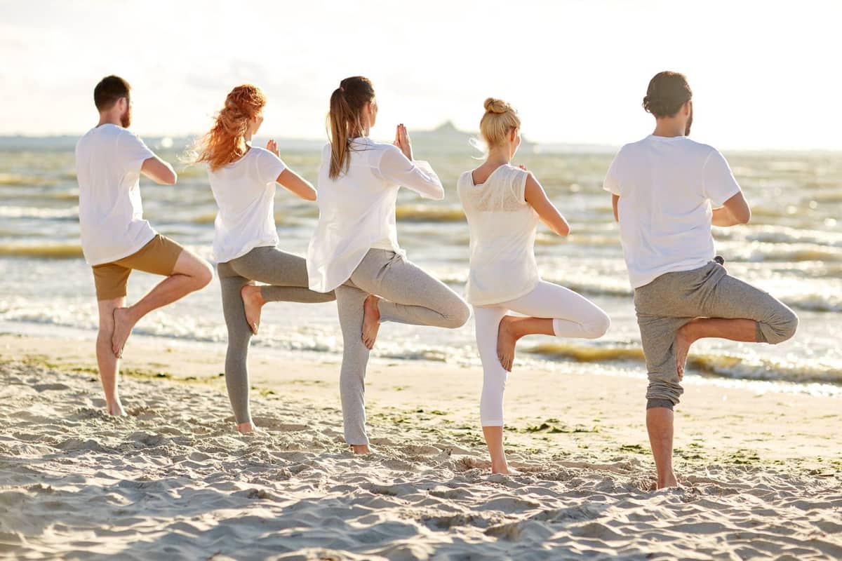 Group yoga practice on the beach at Anahata Samui
