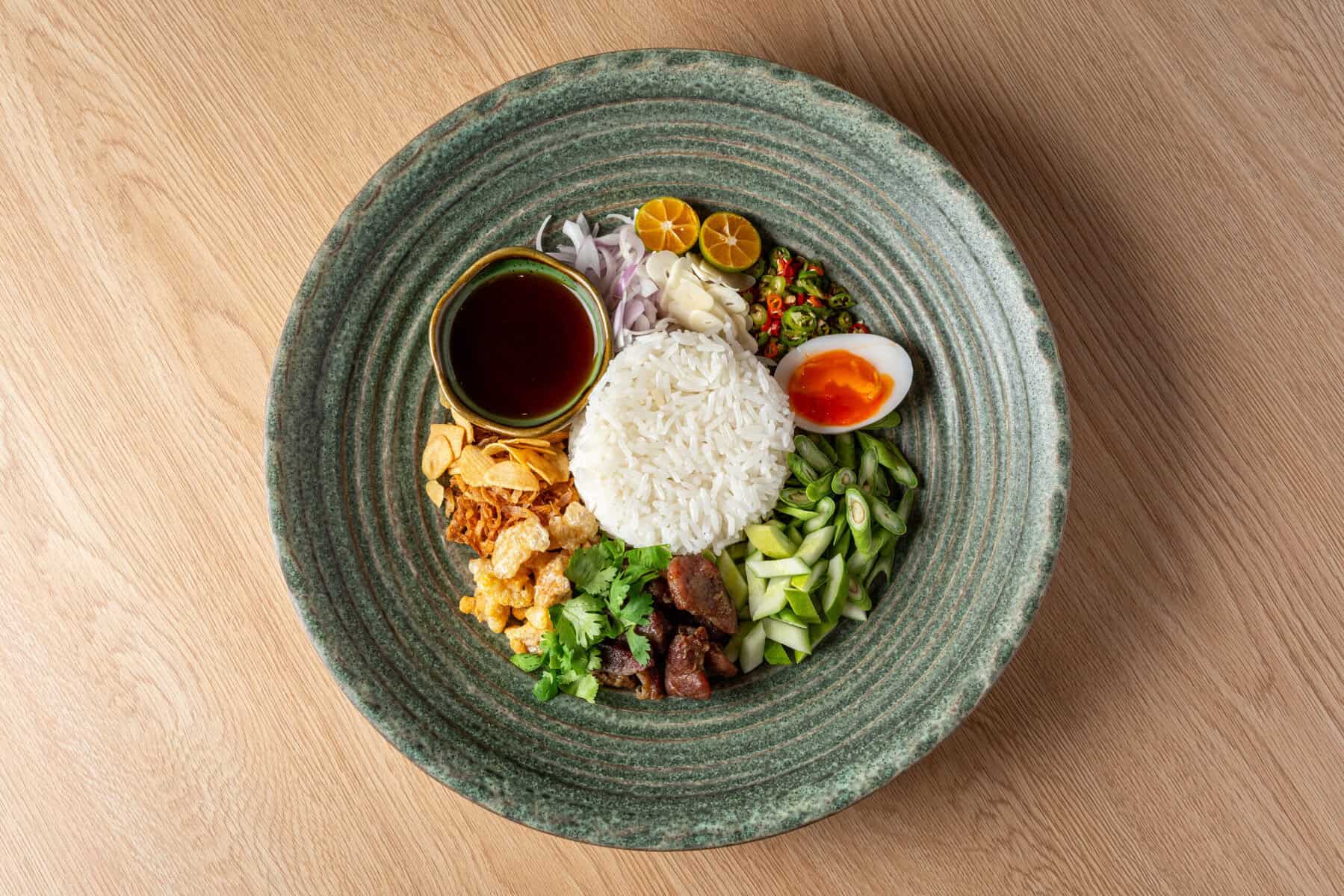 Regional rice dish with herbs and accompaniments at Khum Hom Bangkok