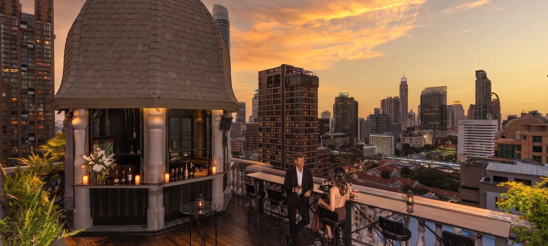 Guests at The Speakeasy Rooftop Bar during sunset