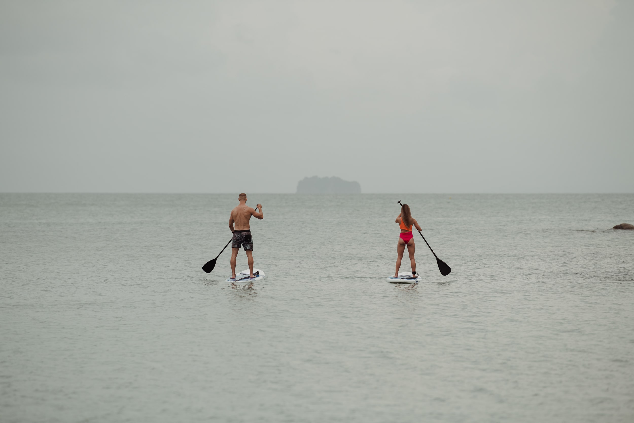 Guests paddleboarding off the coast at Amatara Phuket