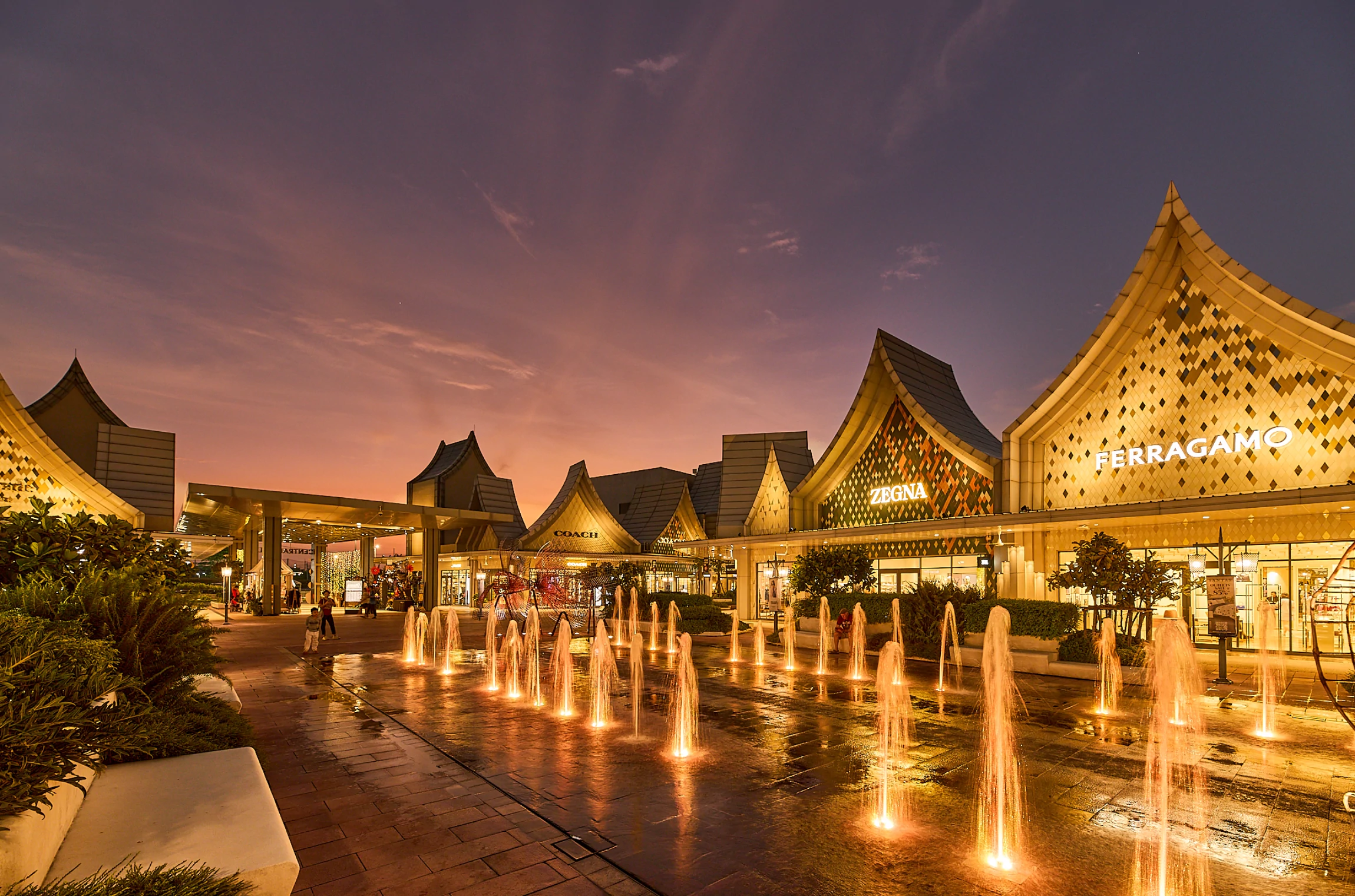 Evening view of Central Village Bangkok Luxury Outlet and its fountains
