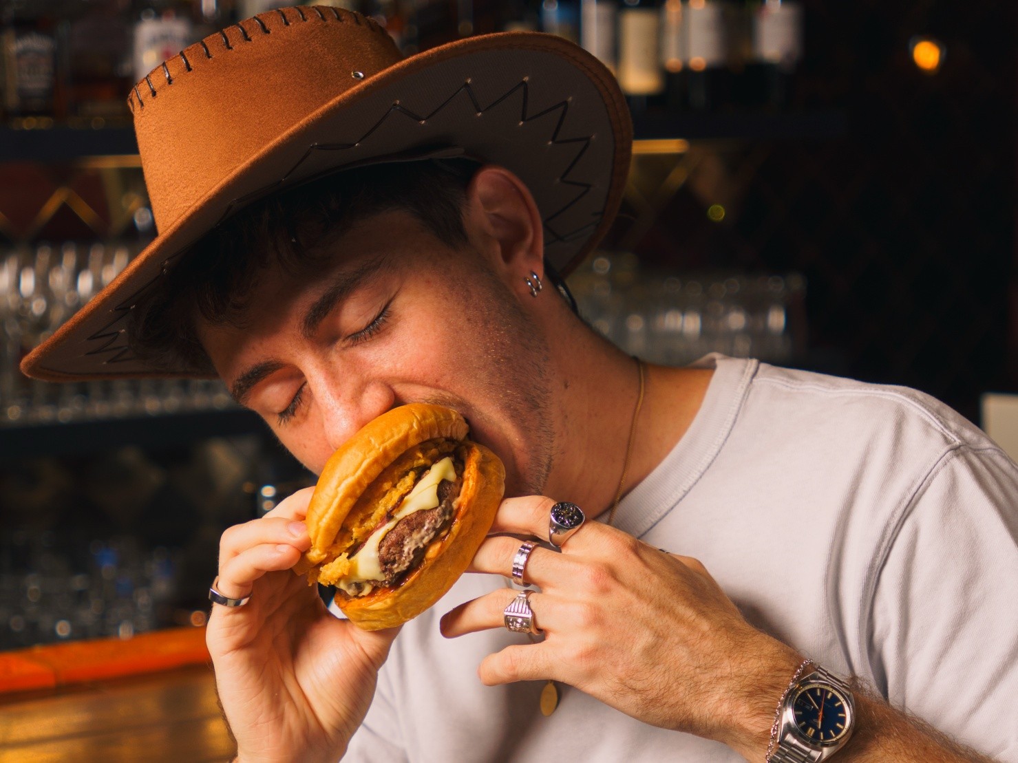 Guest enjoying a burger during the Howdy, 25! campaign