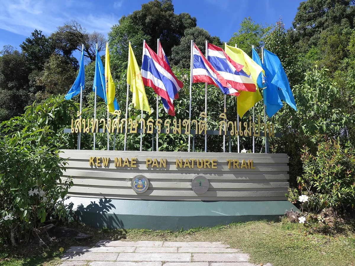 Kew Mae Pan Nature Trail sign with national and royal flags