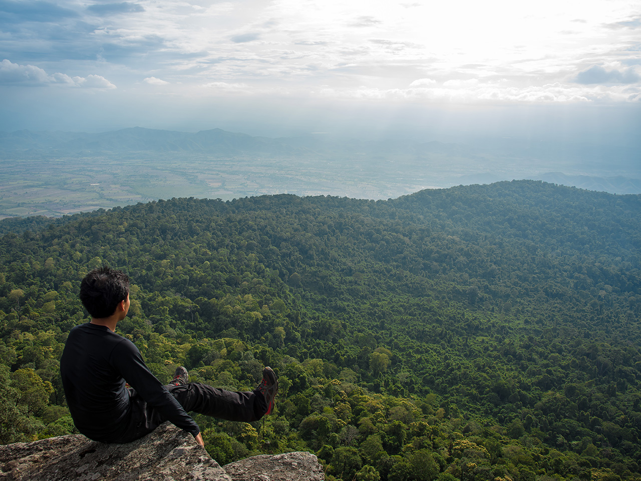 Hiker looking across the forested Khao Luang ridge in Sukhothai
