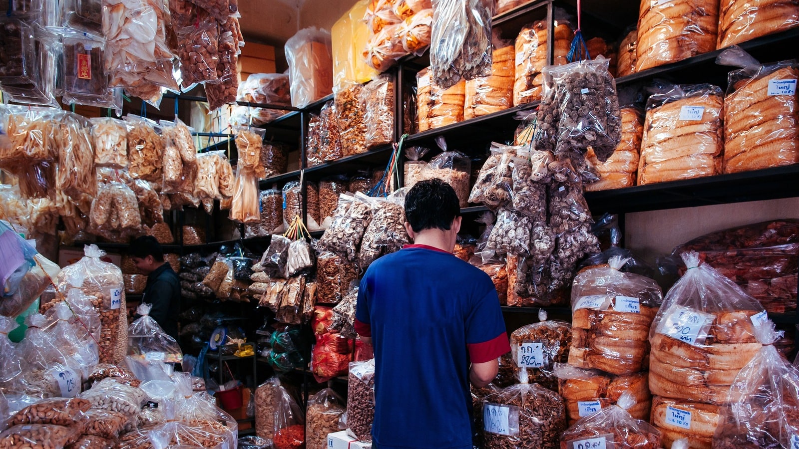 Shopper browsing large bags of dried goods at Kim Yong Market