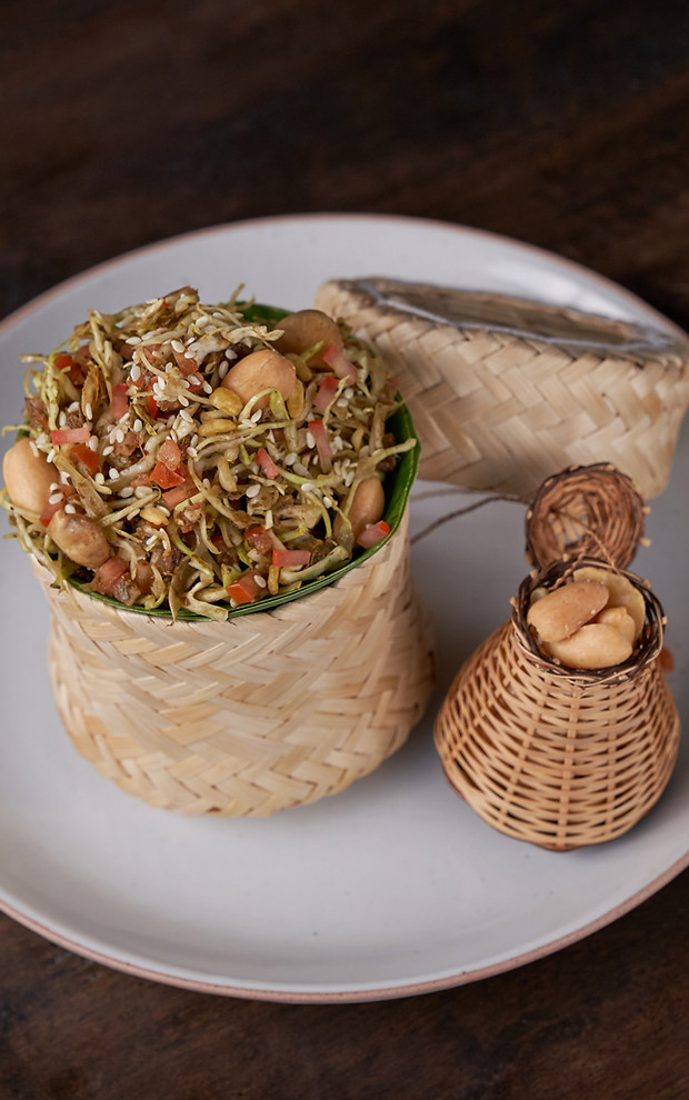 Fermented tea-leaf salad served in woven baskets at Kiti Panit