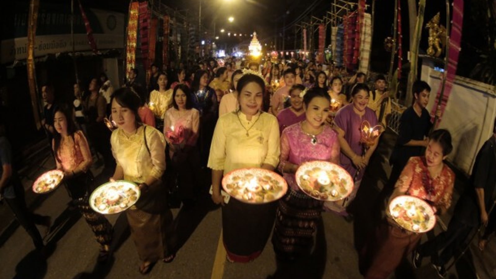 Women in traditional dress carrying candles during Ok Wa