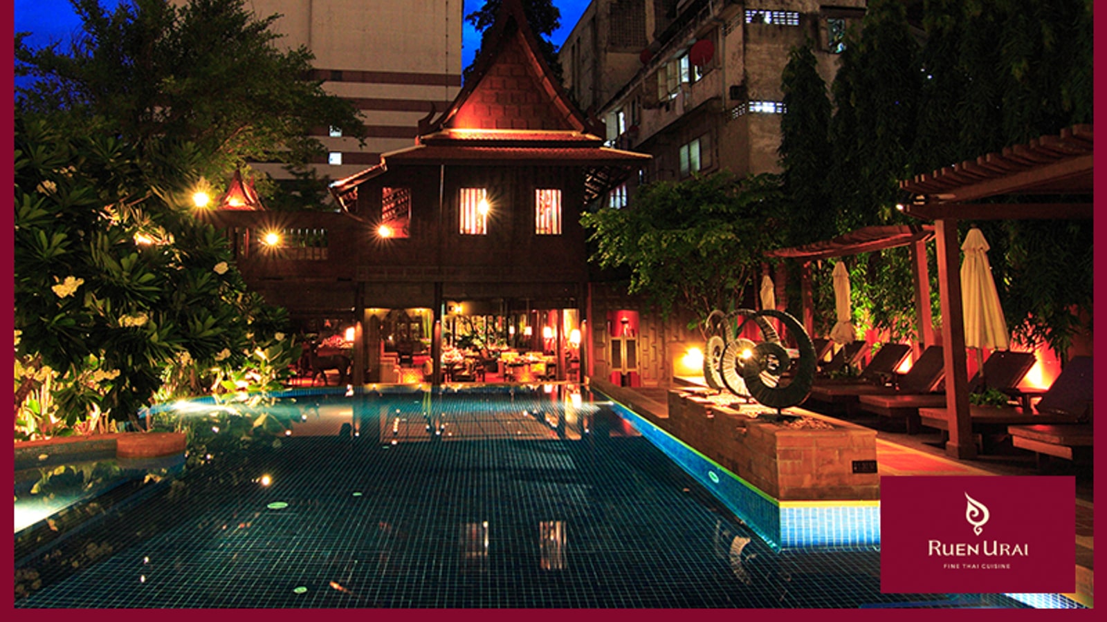 Poolside dining tables beside the Ruen Urai teak house