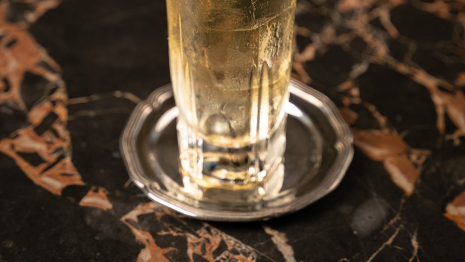 Tall highball cocktail on a dark marble table at BKK Social Club