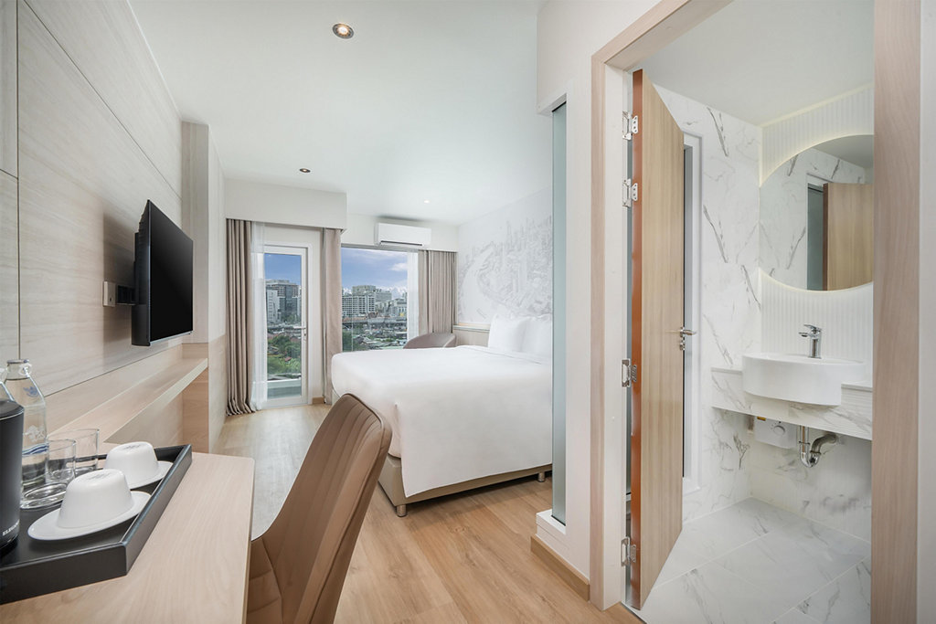 Desk and bathroom entrance in a SureStay Siriraj deluxe room