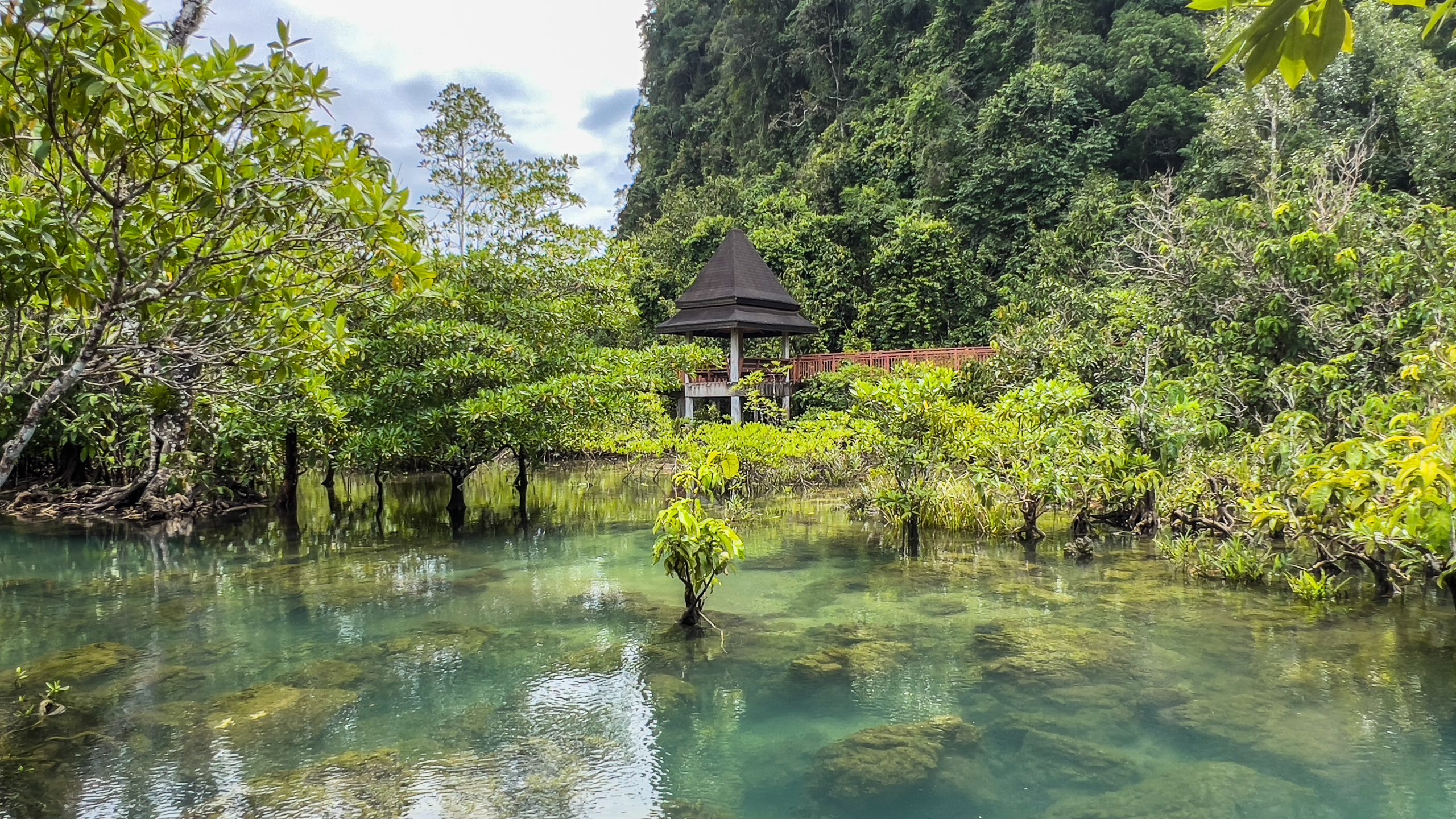 Boardwalk shelter beside clear water at Tha Pom Khlong Song Nam