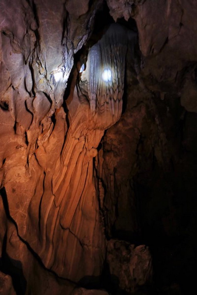 Illuminated limestone formations inside Tham Pha Thai cave