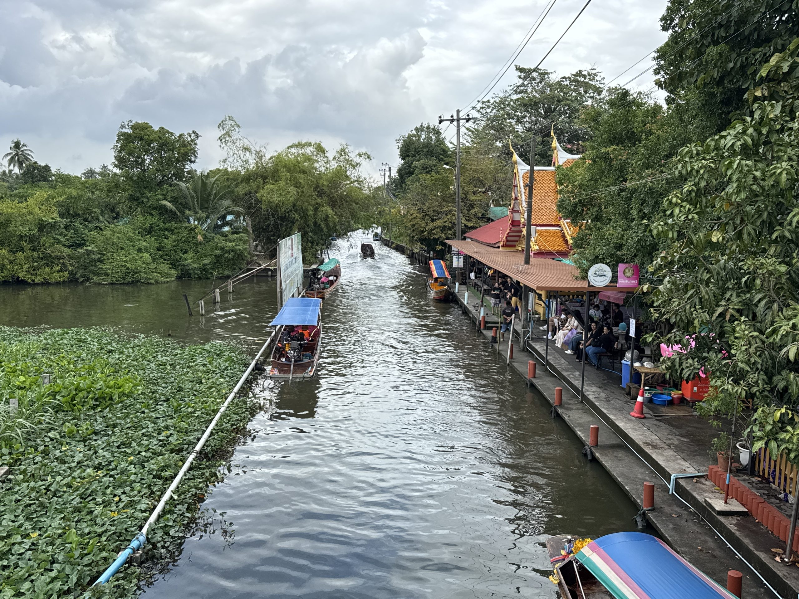 Canal scene and temple buildings at Wat Saphan Floating Market