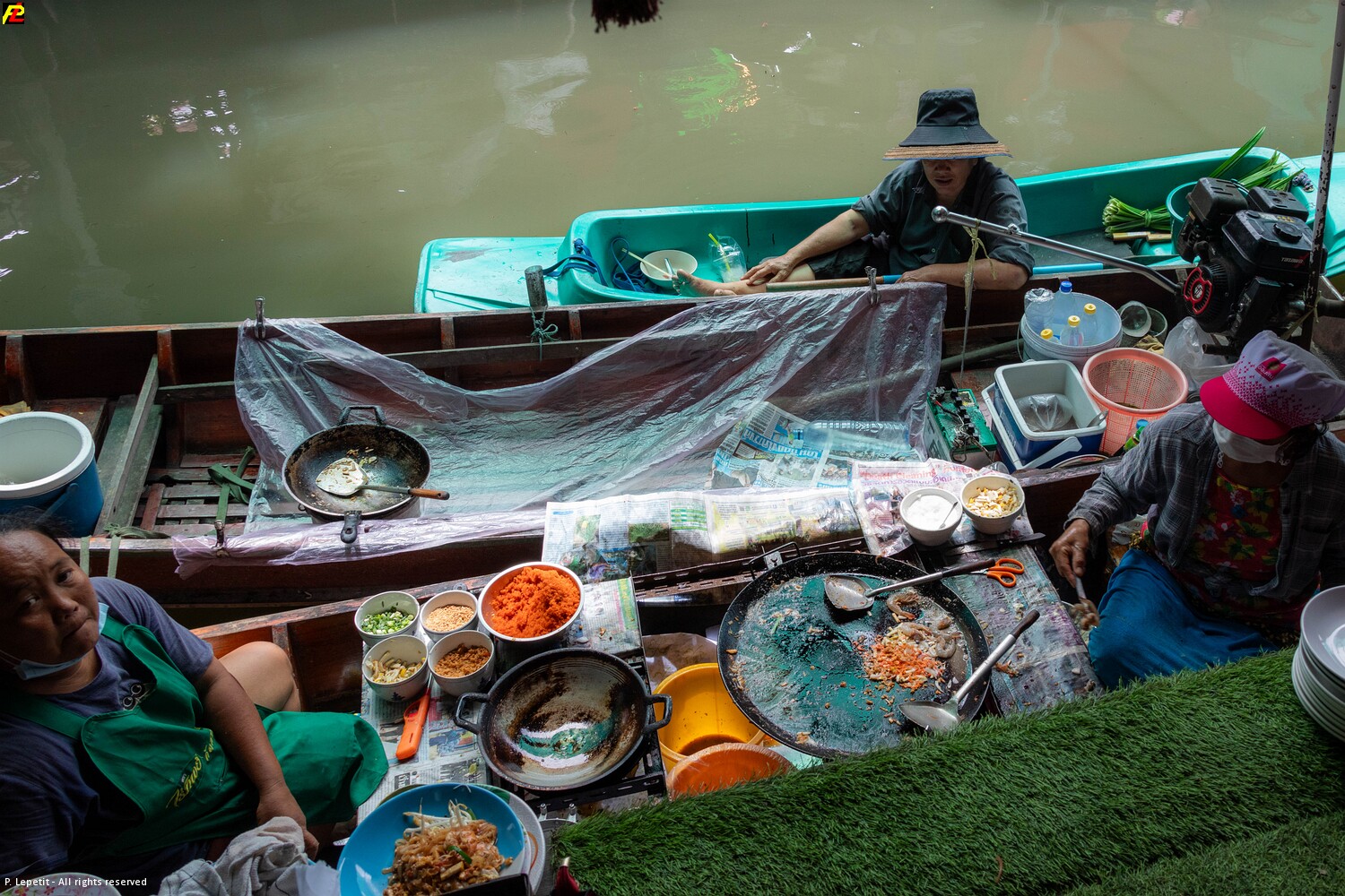A food vendor preparing dishes from a boat at Wat Saphan